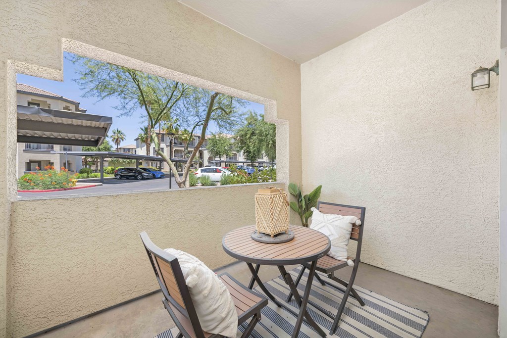 a patio with a table and chairs and a large window