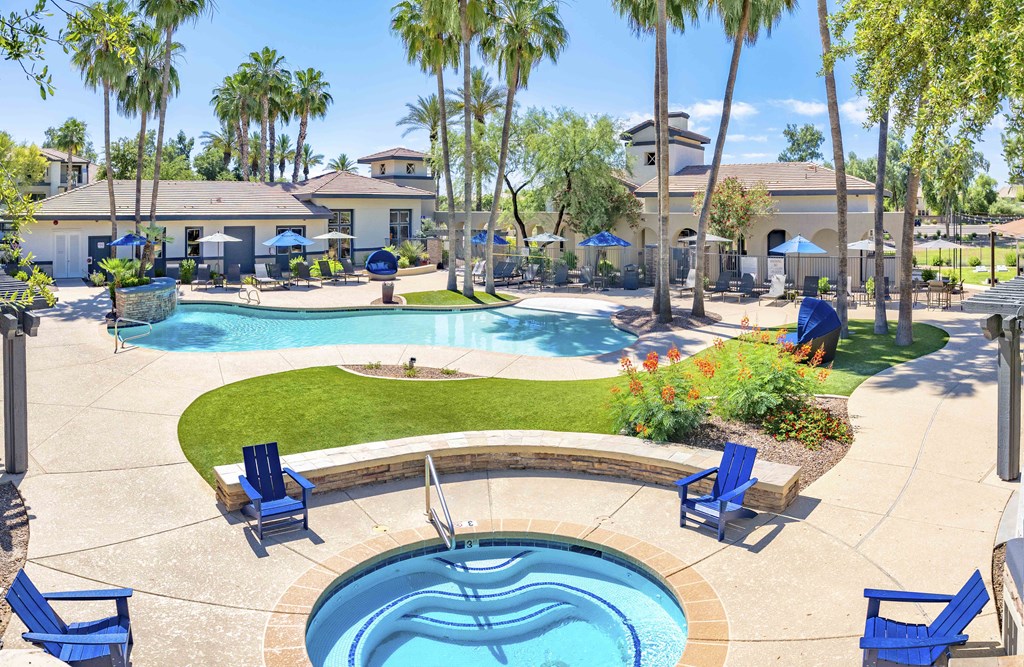 a swimming pool with blue chairs around it and palm trees