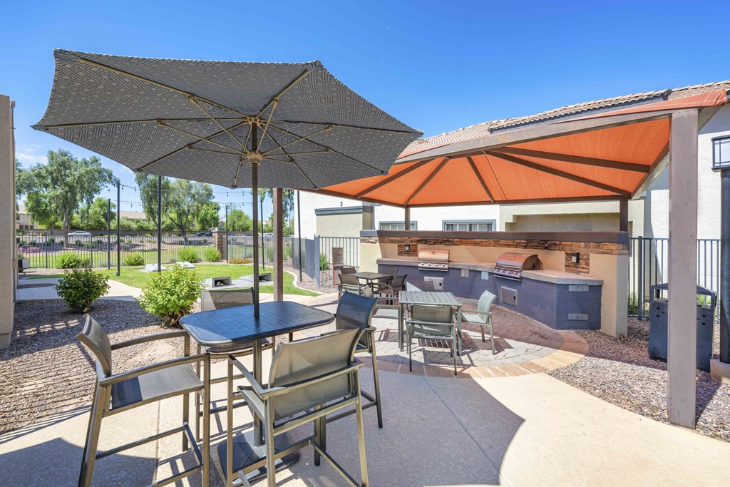 a patio with tables and chairs and umbrellas