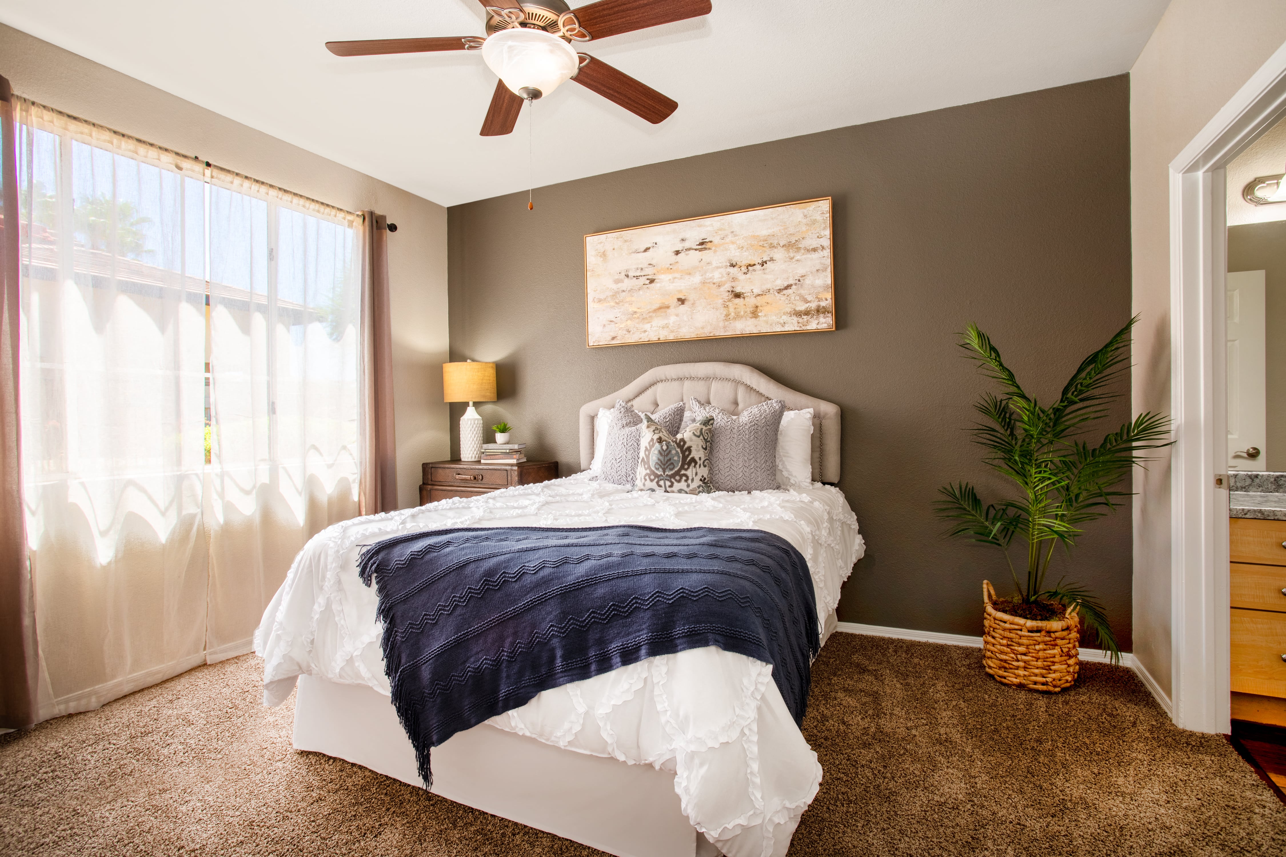 a bedroom with a bed and a ceiling fan