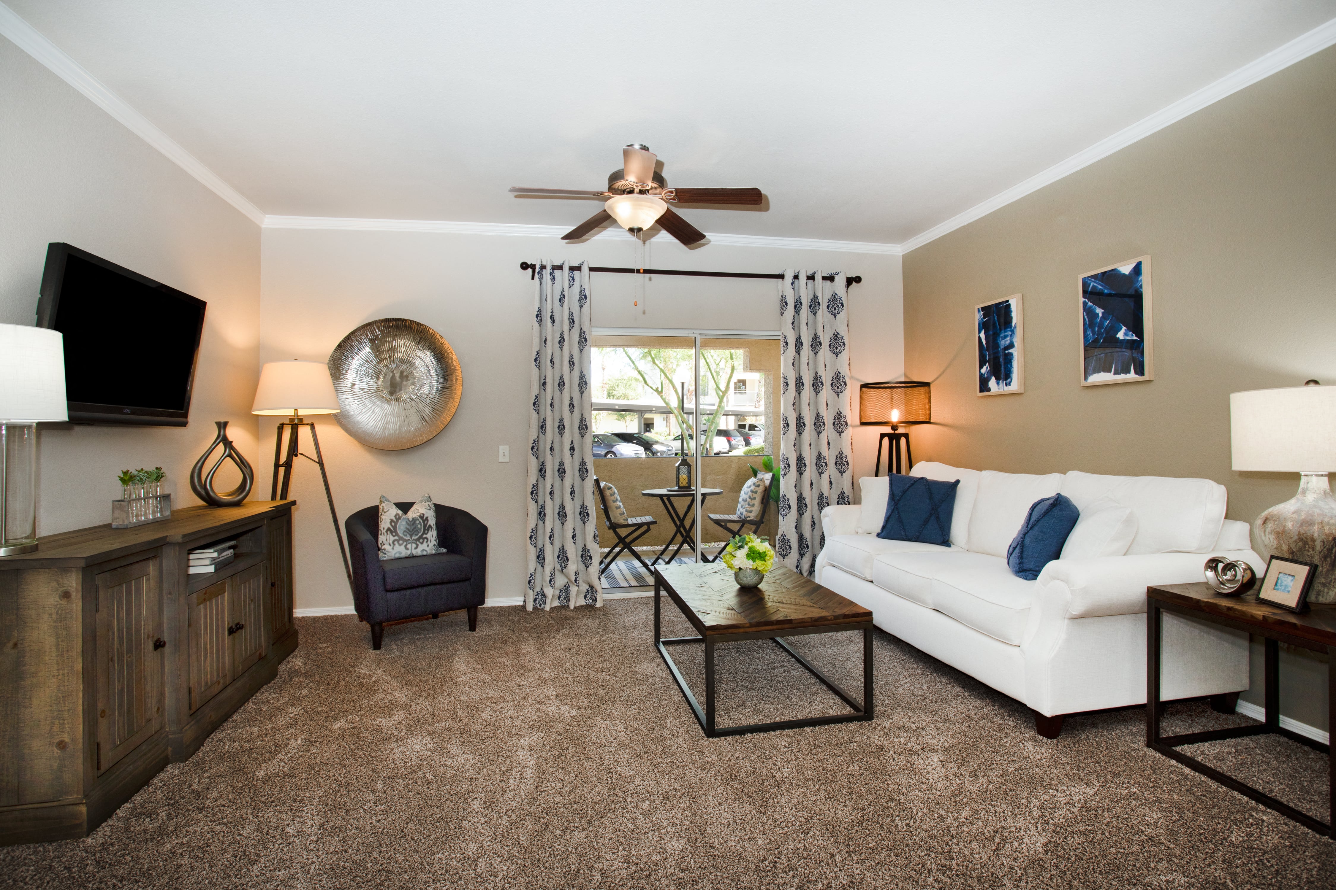 a living room with a white couch and a ceiling fan