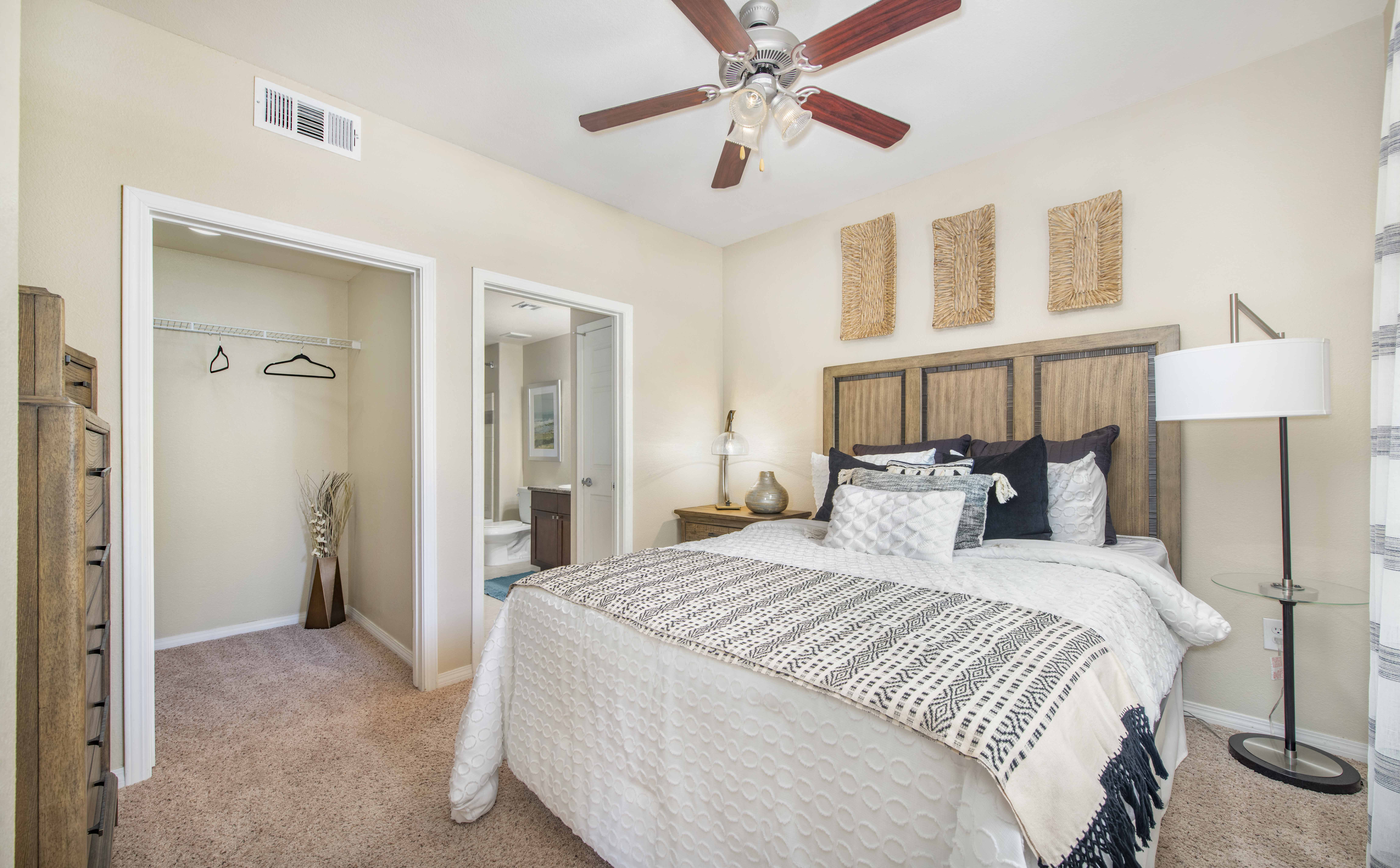 a bedroom with a large bed and a ceiling fan