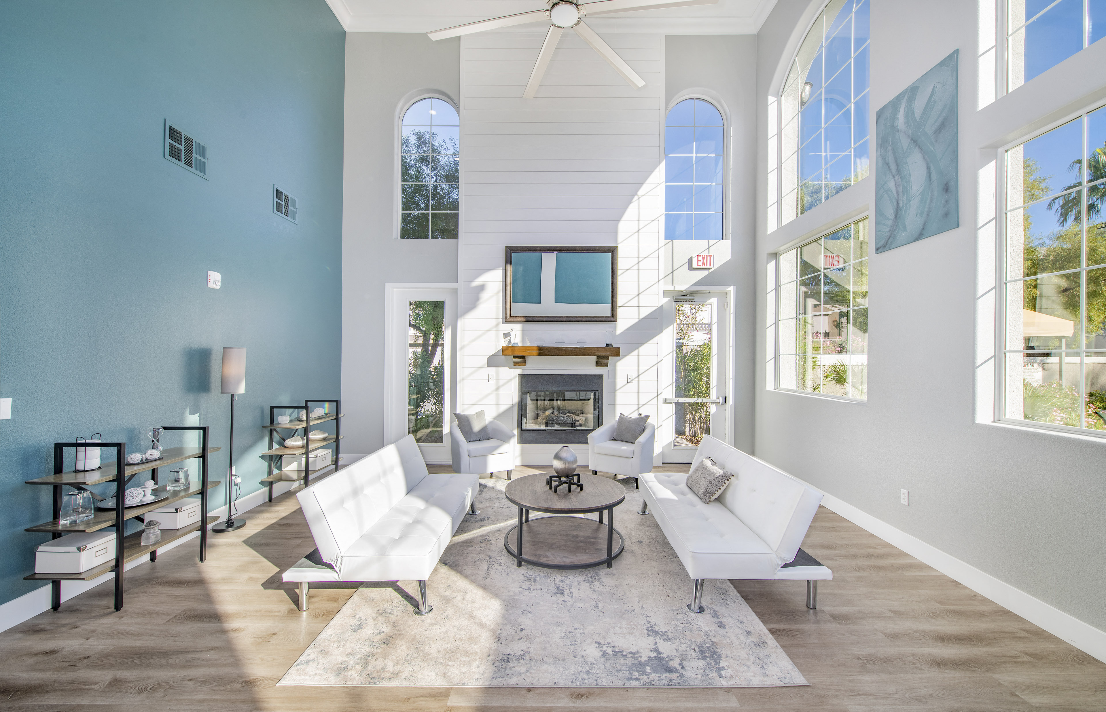 a living room with blue walls and white furniture and a fireplace