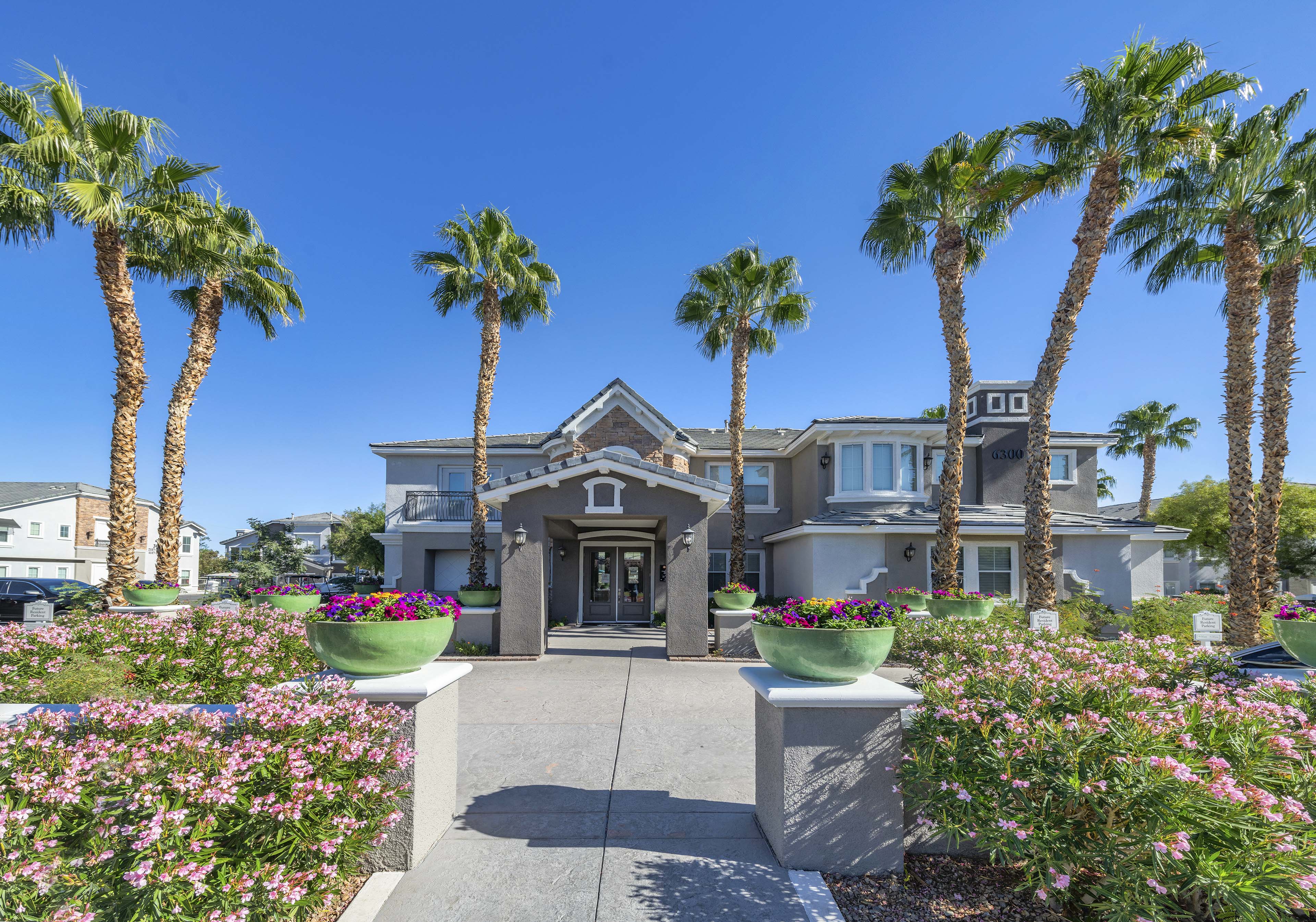 the front of a house with palm trees in front of it