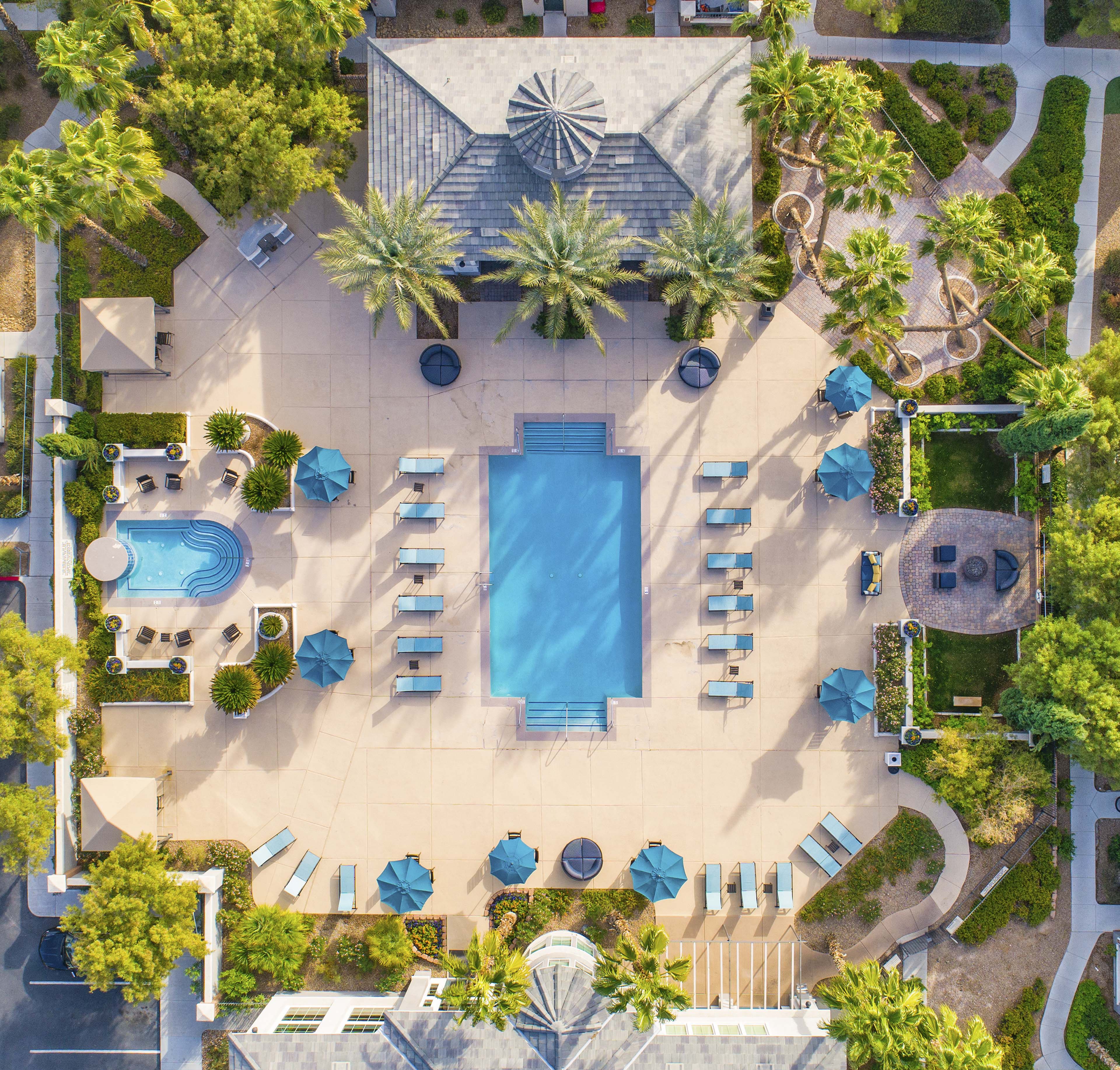 a pool area with umbrellas and chairs and a swimming pool
