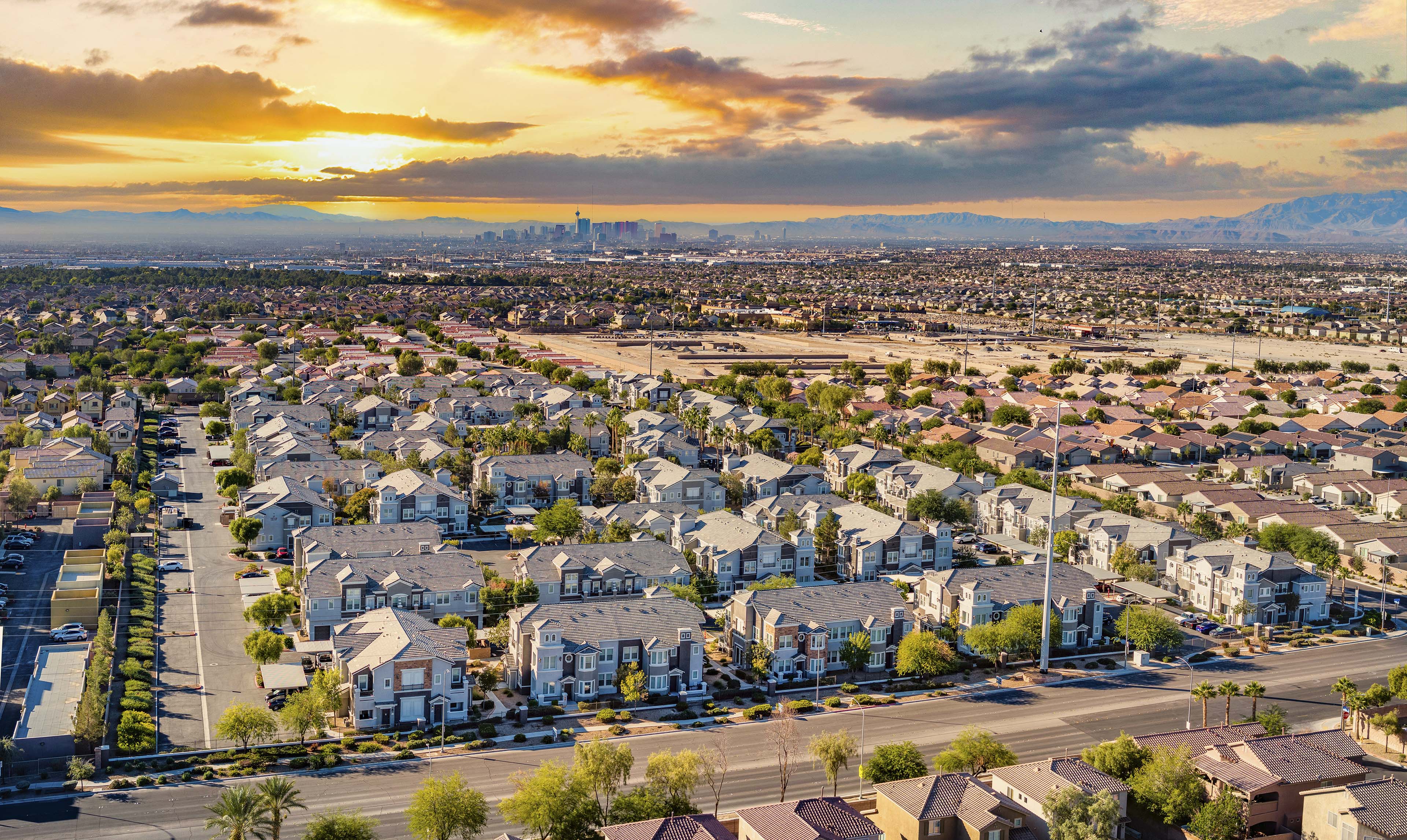 an aerial view of a neighborhood with houses and a sunset