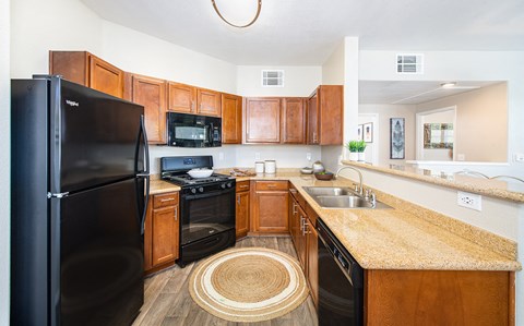 a kitchen with black appliances and wooden cabinets