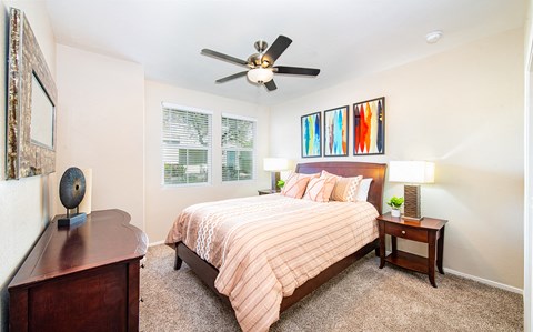 a bedroom with a bed and a ceiling fan