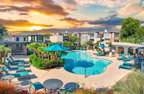 A beautiful outdoor swimming pool area with loungers and umbrellas.