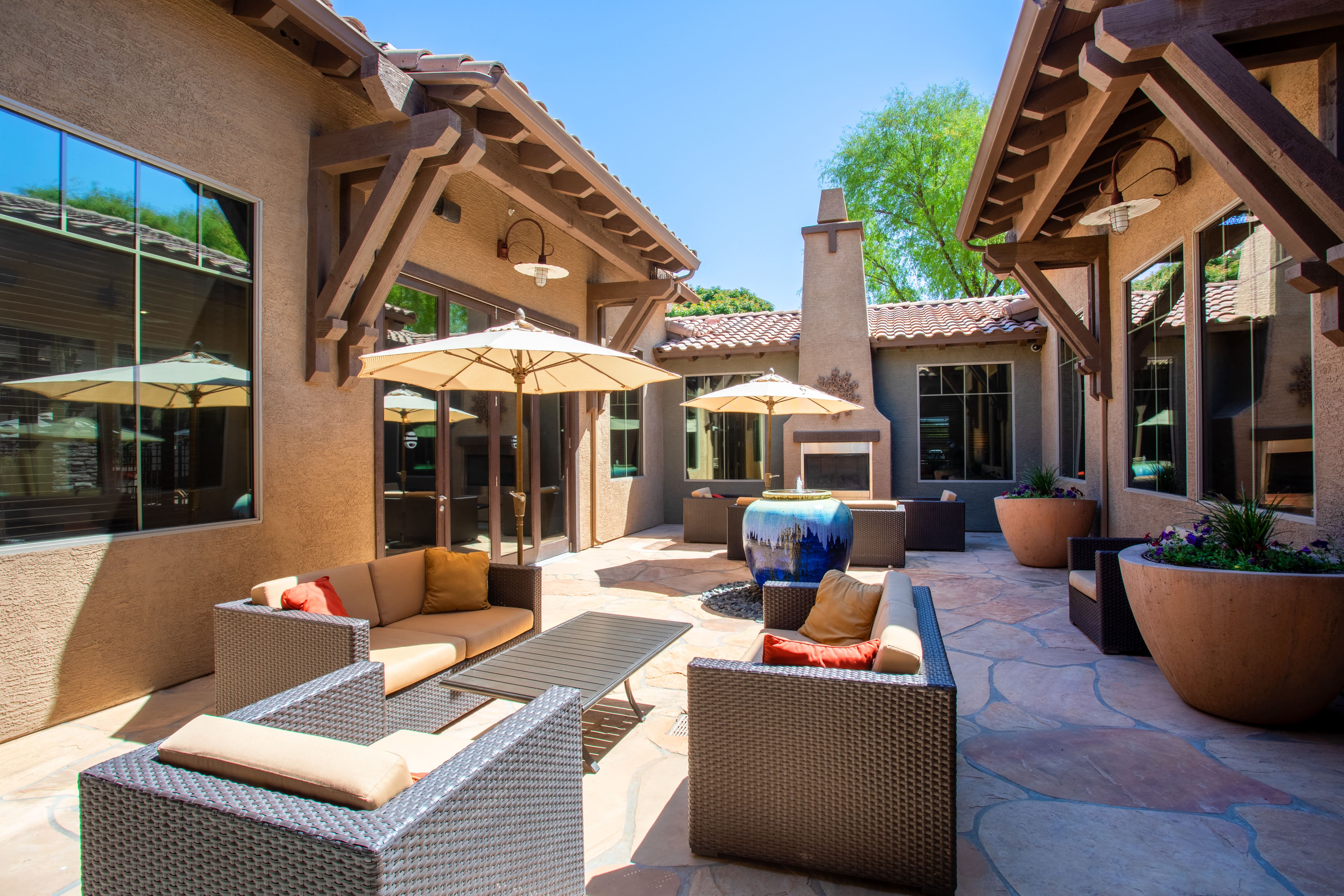 a patio with furniture and umbrellas outside of a house