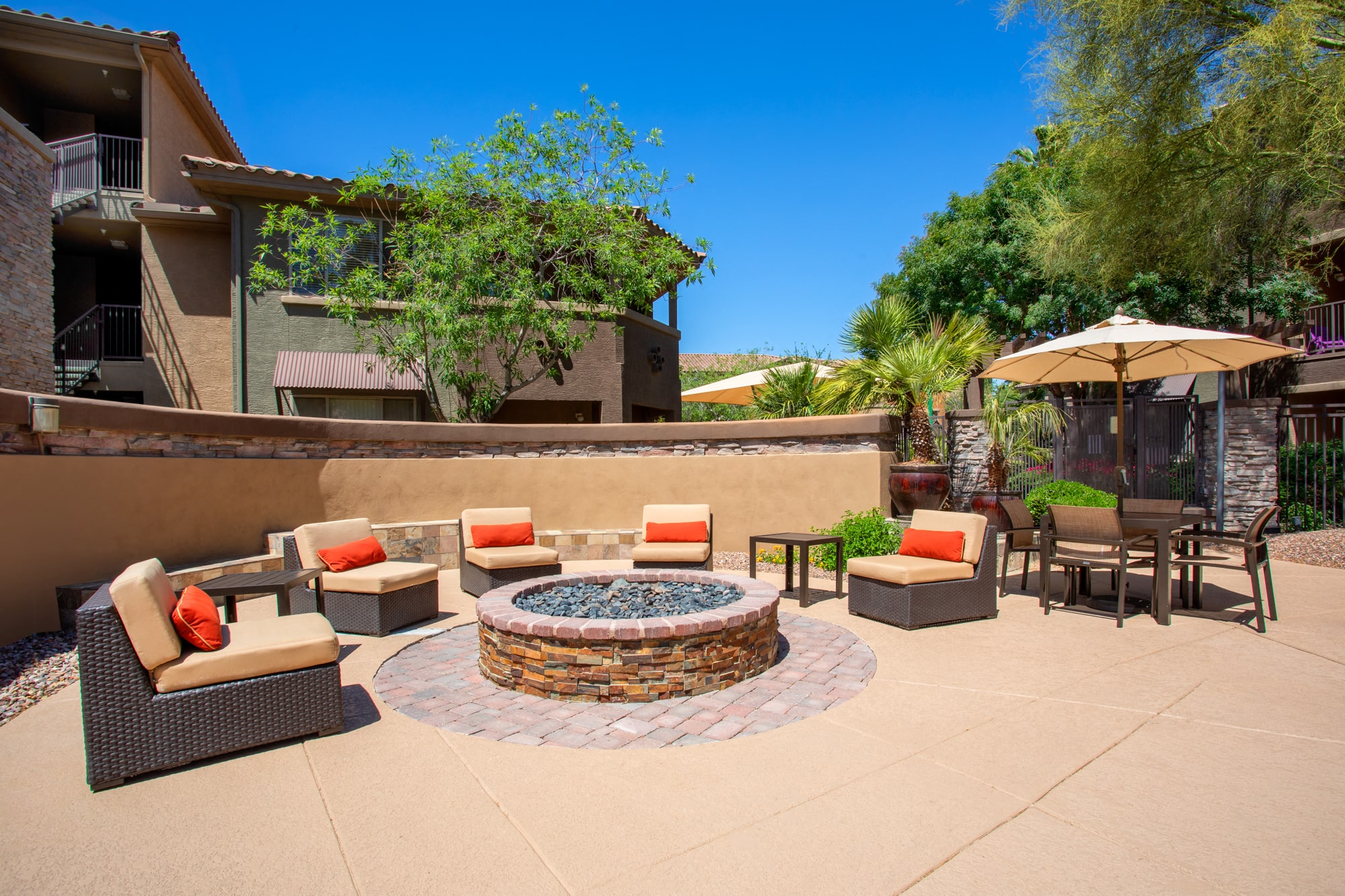 a patio with a fire pit and chairs and tables