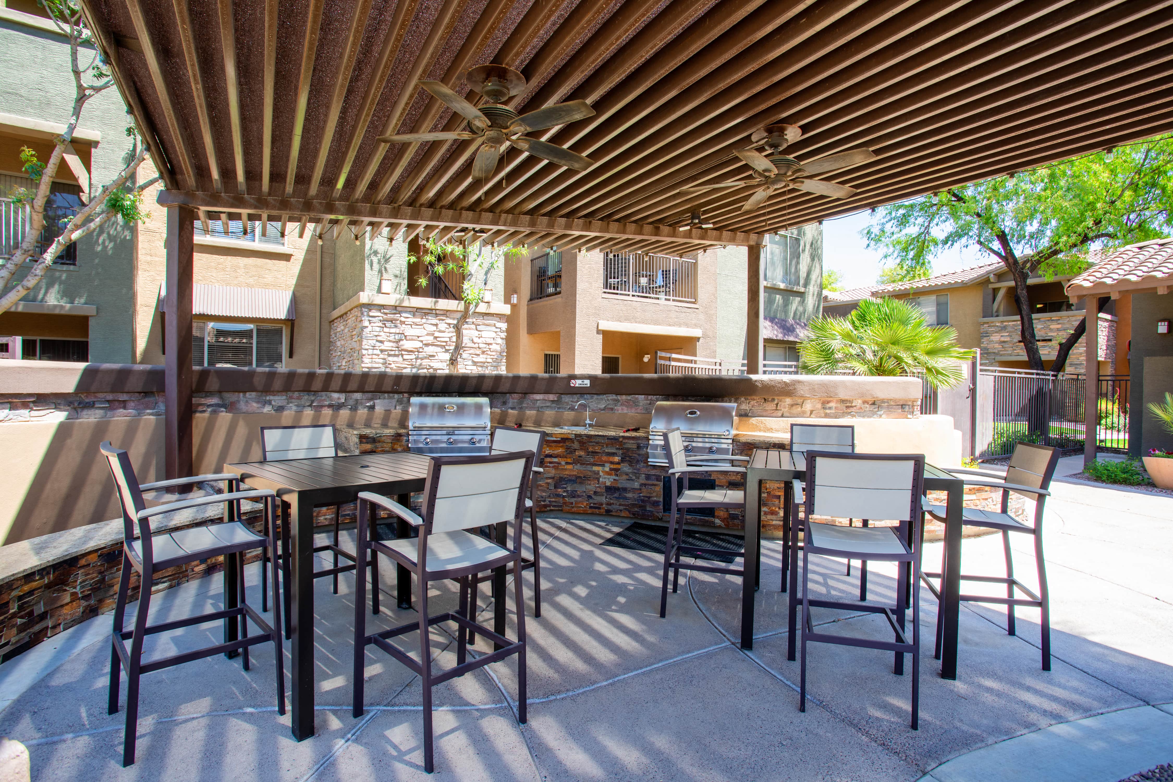 a covered patio with tables and chairs and a bar