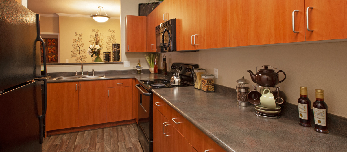 a kitchen with stainless steel counter tops and wooden cabinets