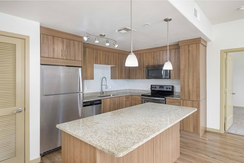 A kitchen with wooden cabinets and a granite countertop.