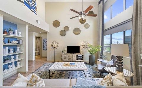 A living room with a white couch, a coffee table, and a television.