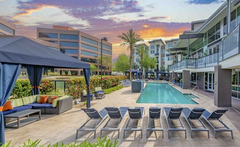 A pool surrounded by lounge chairs and umbrellas.