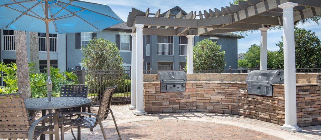 a patio with a table and chairs and an umbrella
