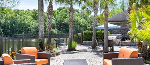 a backyard patio with chairs and tables and trees
