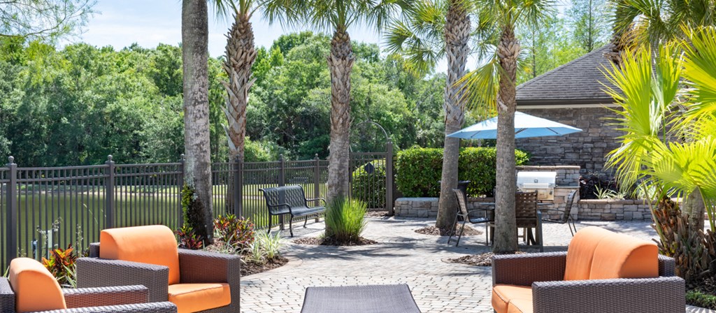 a backyard patio with chairs and tables and trees