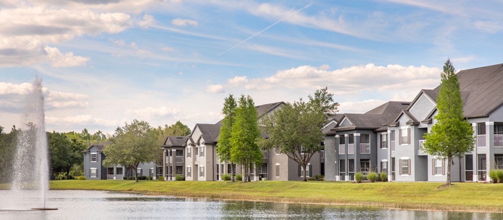 an image of a pond in front of some houses