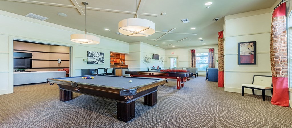 a game room with two pool tables and a bar