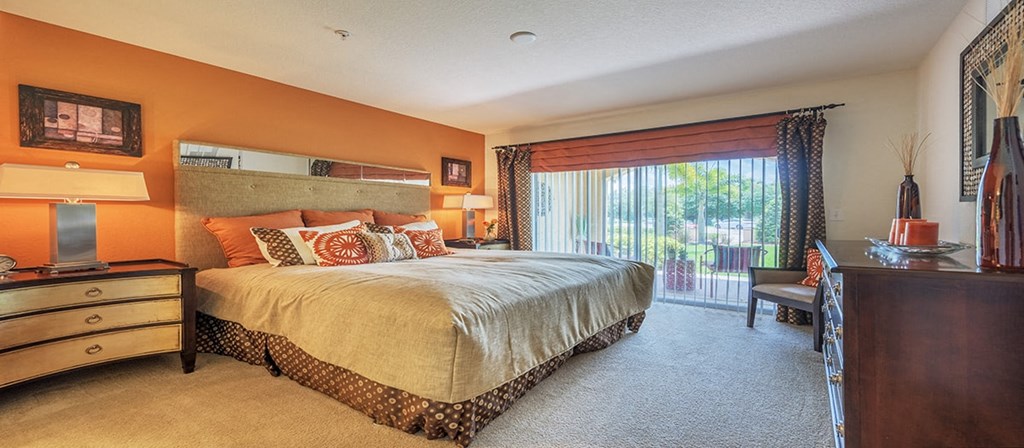 a bedroom with a bed and a sliding glass door
