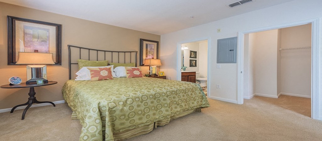 a bedroom with a bed and a door to a bathroom