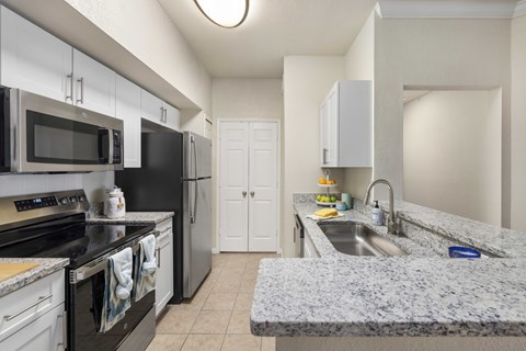 A kitchen with granite countertops and stainless steel appliances.