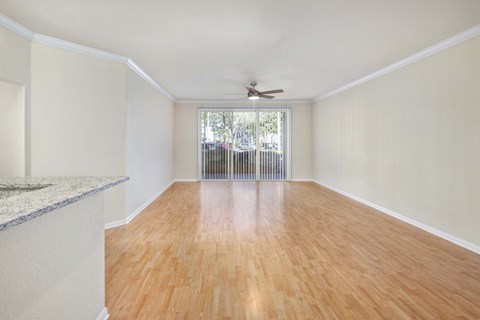 A room with wooden floors and a ceiling fan.