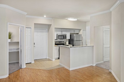 A kitchen with white cabinets and a white island.