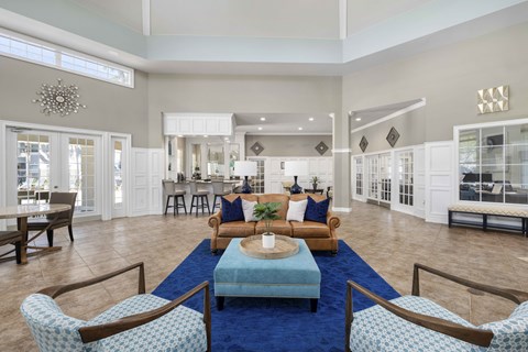 A living room with a blue rug and wooden furniture.