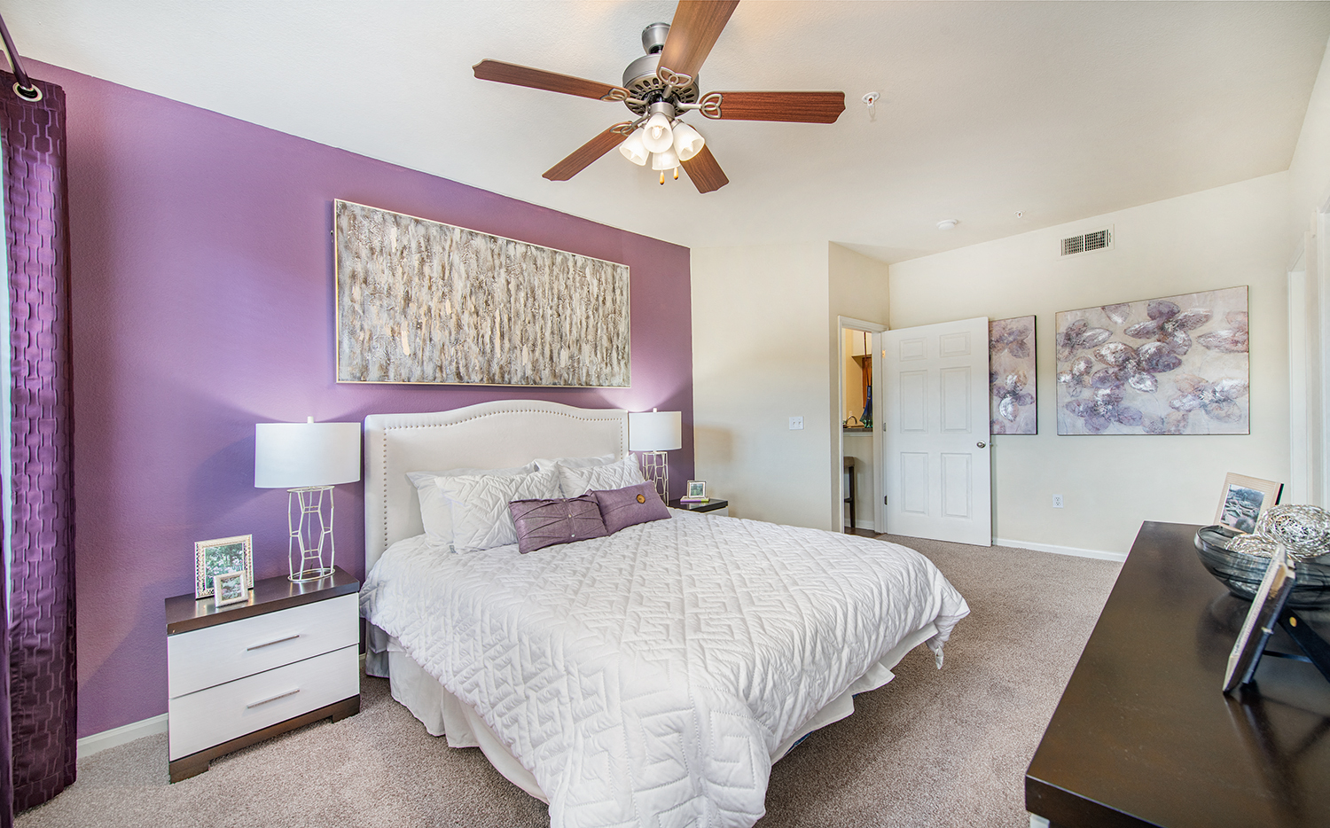 a bedroom with a large bed and a ceiling fan