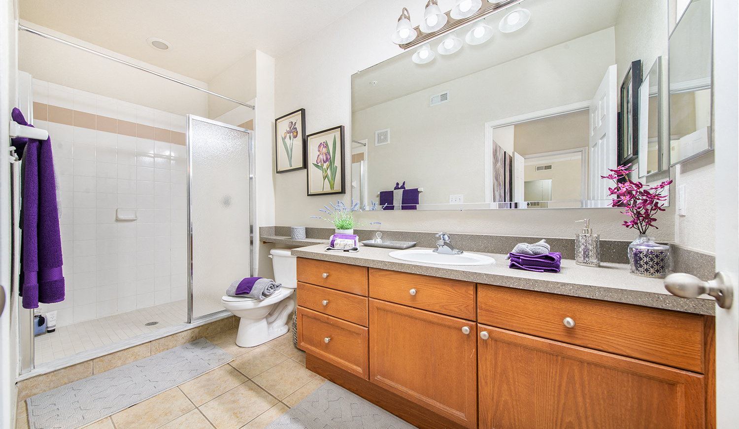 a bathroom with a large mirror and wooden cabinets