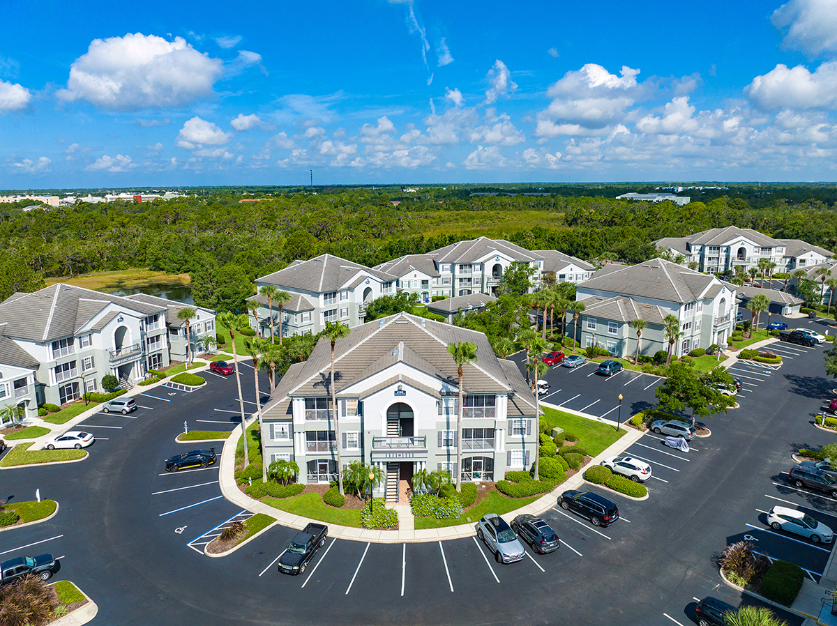 an aerial view of a large building with cars parked in front of it