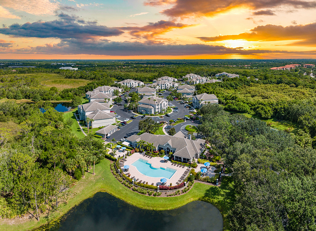 an aerial view of the resort with a pool and lake