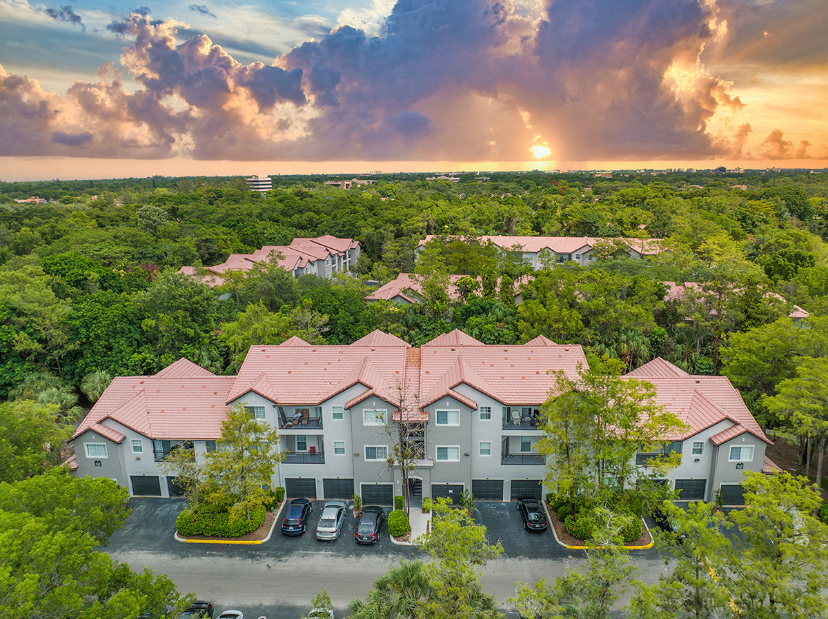 aerial view of the apartments at dusk with the sun setting behind the trees