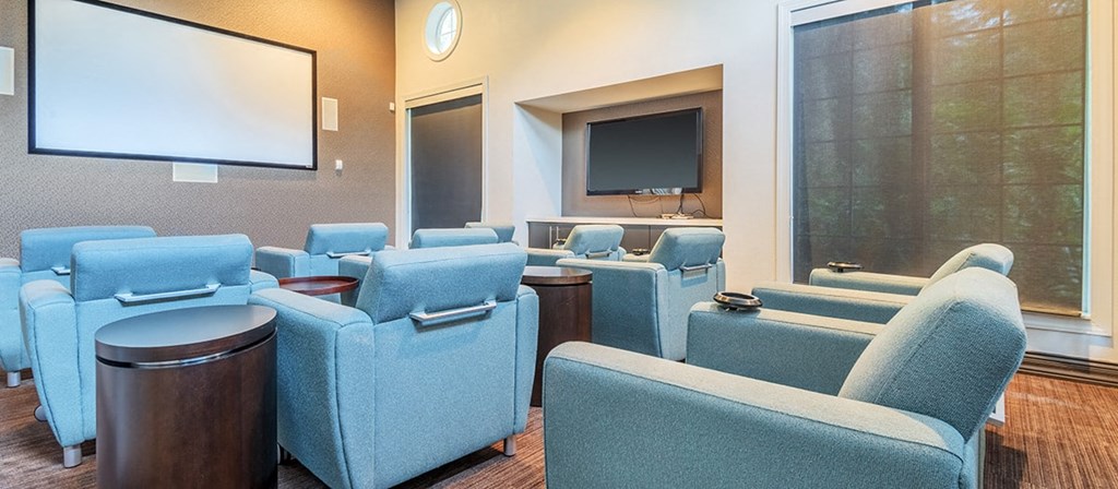 a conference room with blue chairs and a projector screen