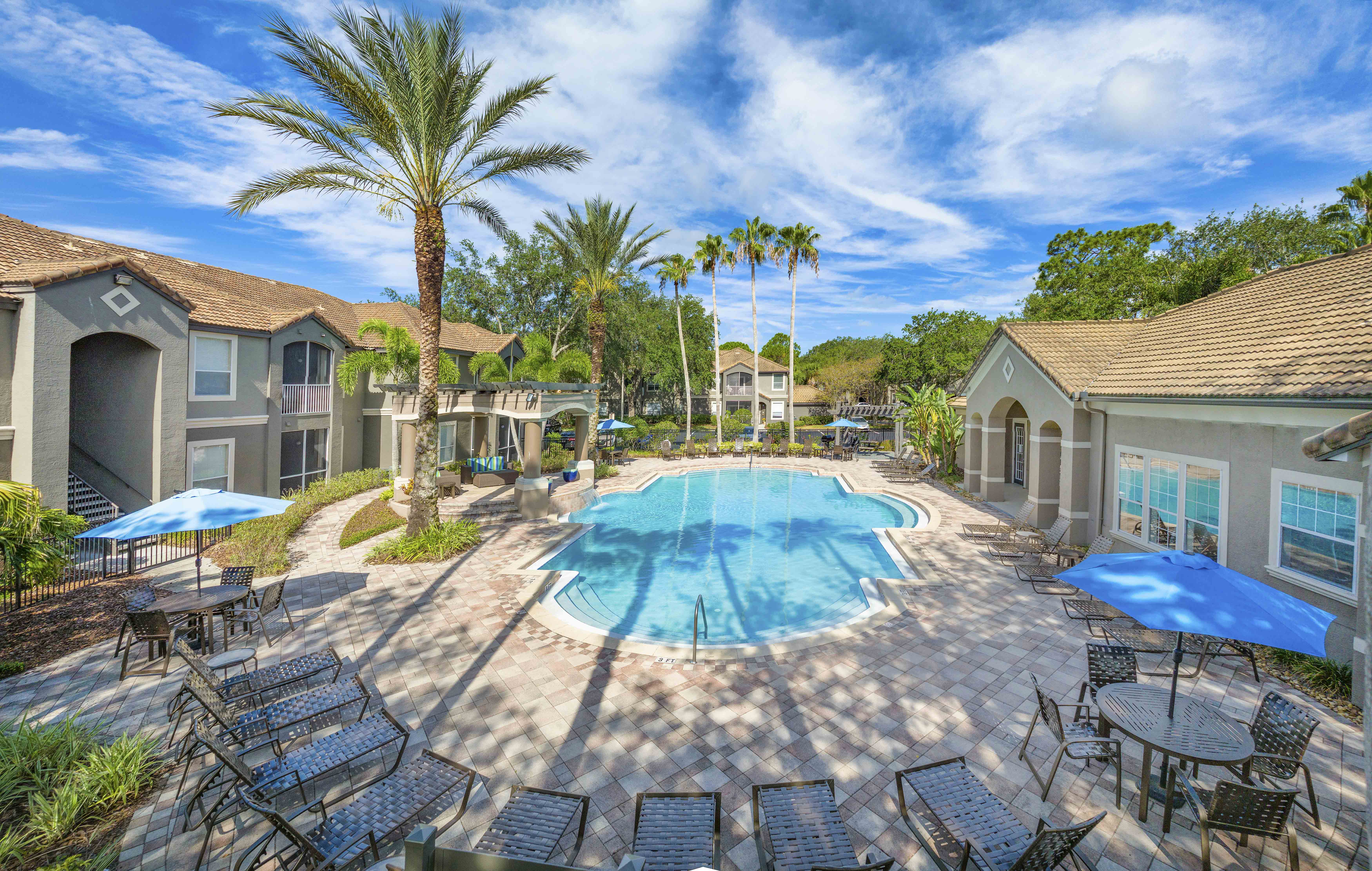 a large swimming pool with chairs and umbrellas
