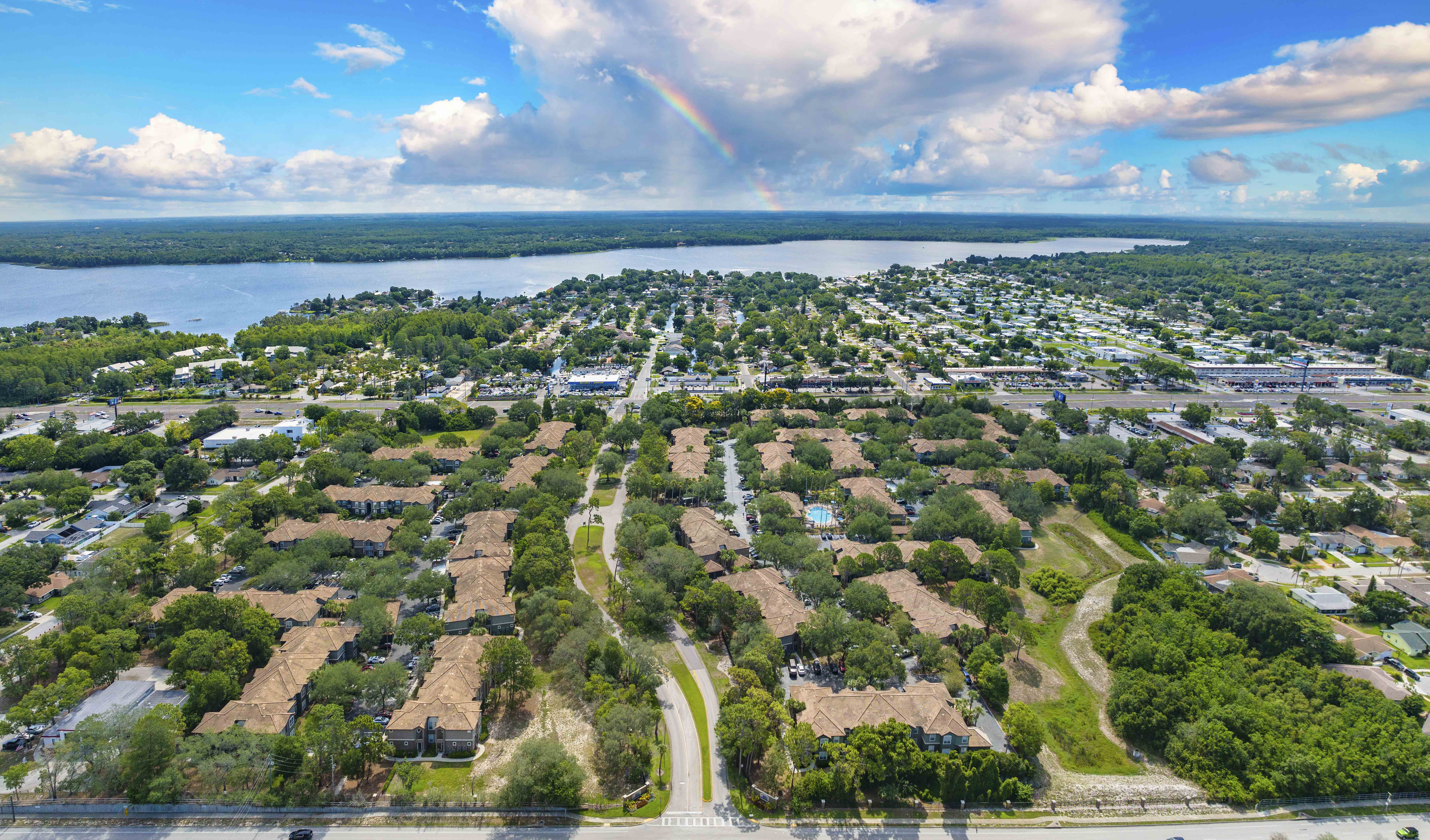 an aerial view of a neighborhood with a rainbow in the sky