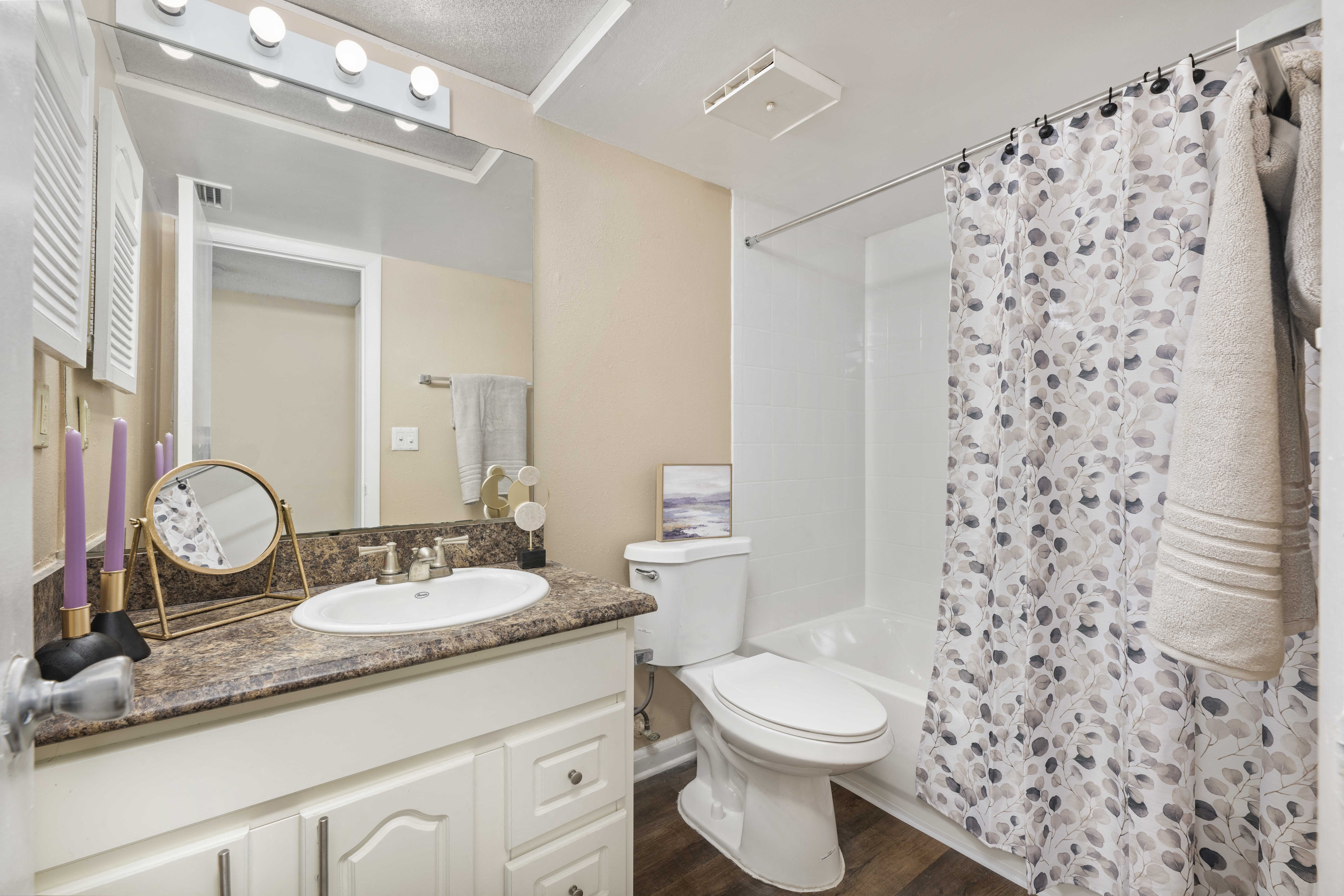 a bathroom with a shower curtain and a toilet and sink