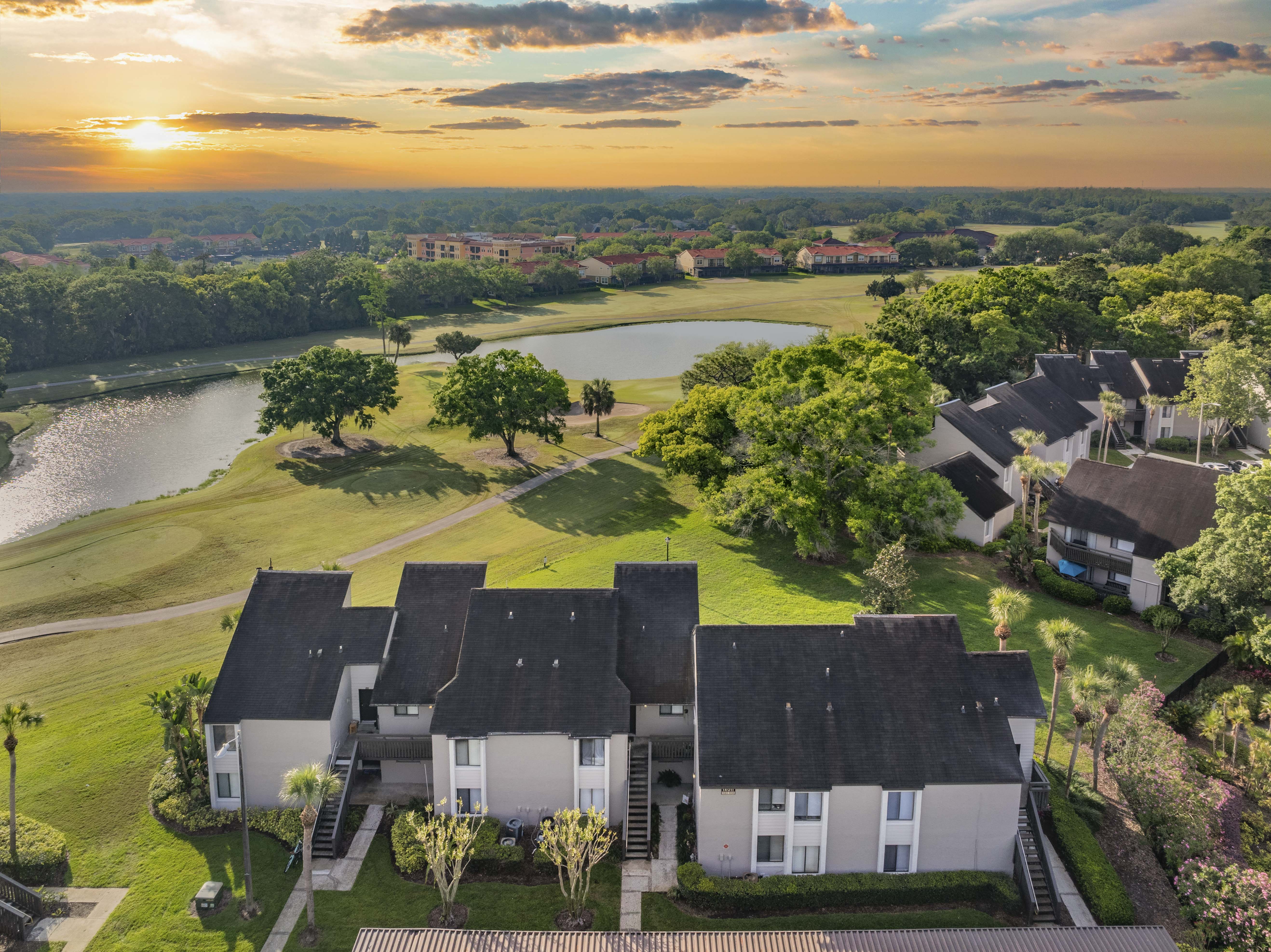 an aerial view of a neighborhood with houses and a pond