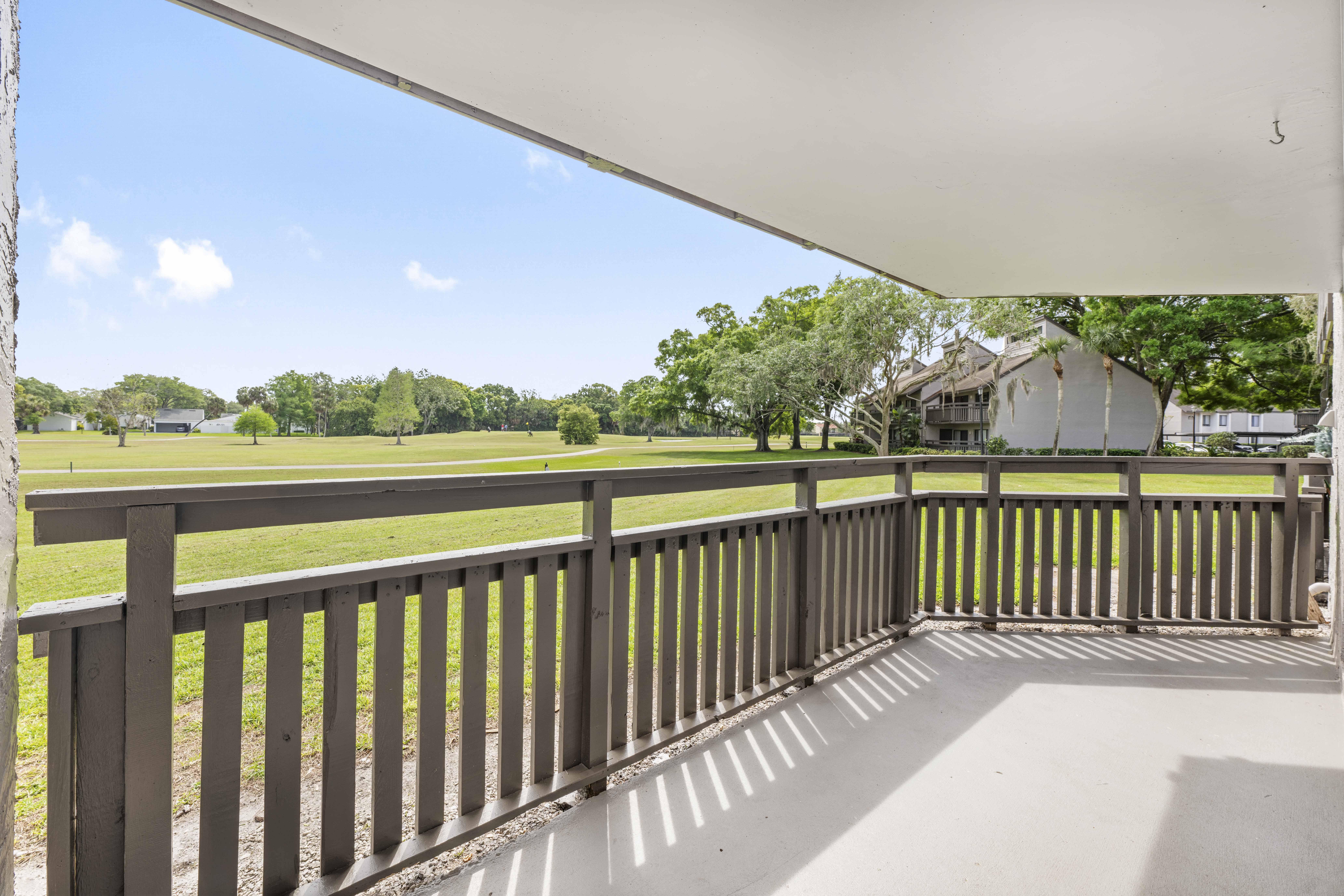 the view from the deck of a house overlooking a golf field