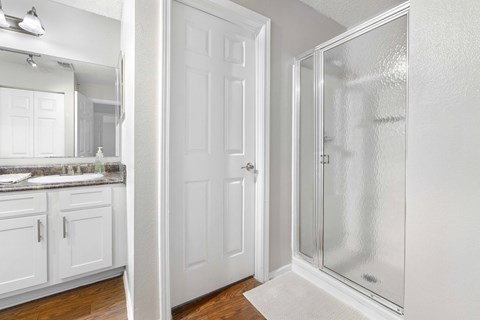 A white bathroom with a glass shower door.