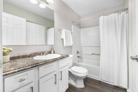 A white bathroom with a sink, toilet, and bathtub.