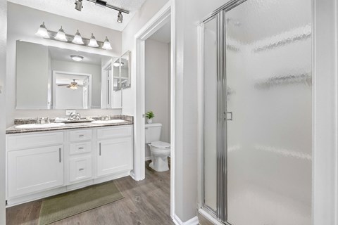 A white bathroom with a walk in shower.