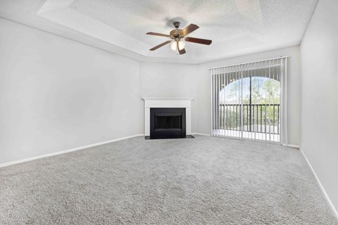 A room with a fireplace and a ceiling fan.