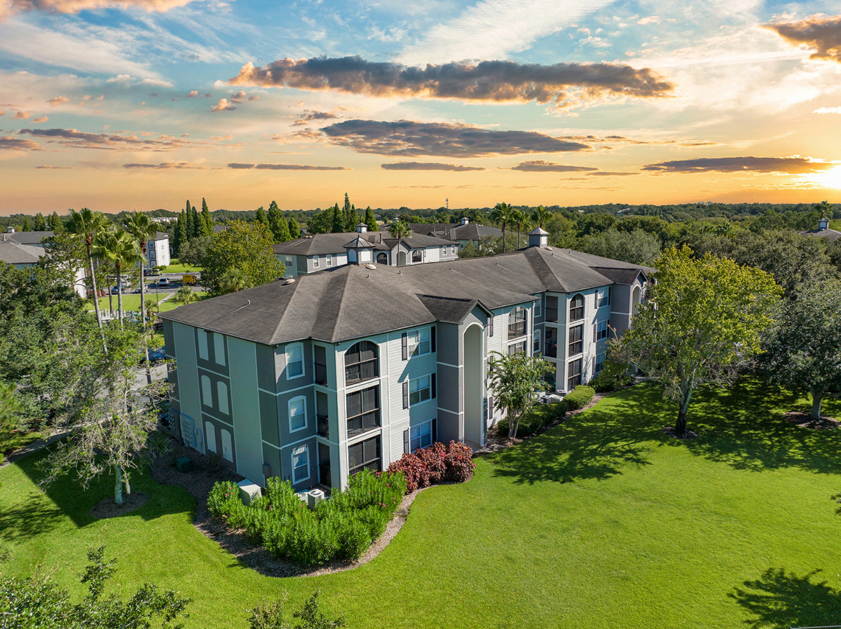 an aerial view of a building with a sunset in the background