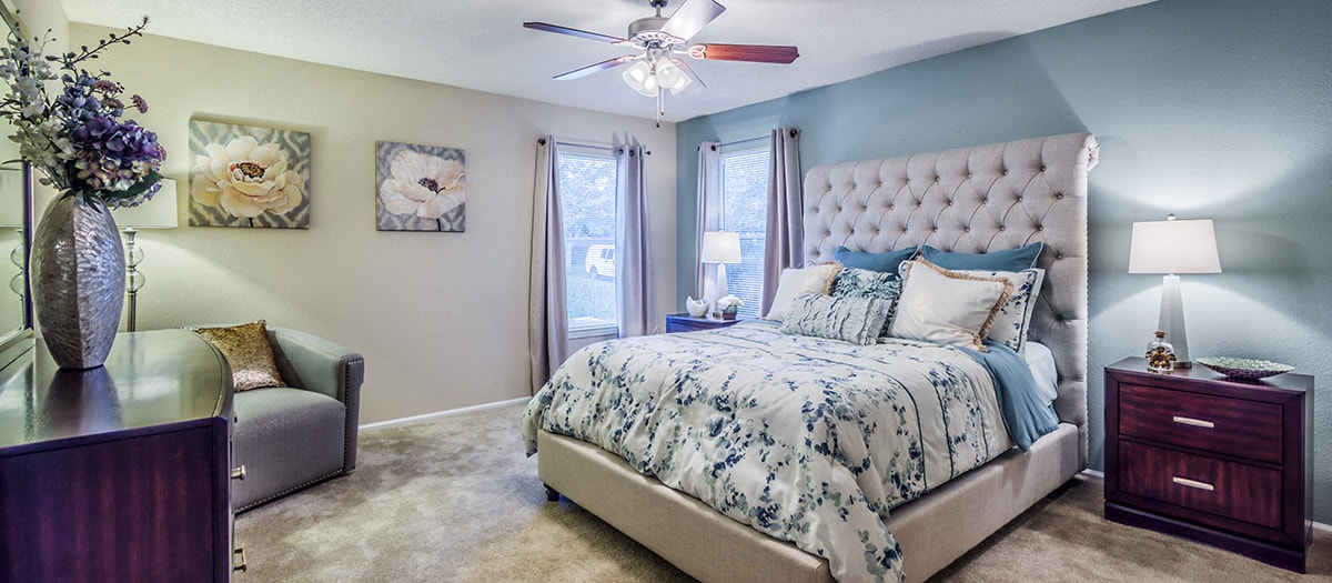 a bedroom with a bed and a ceiling fan