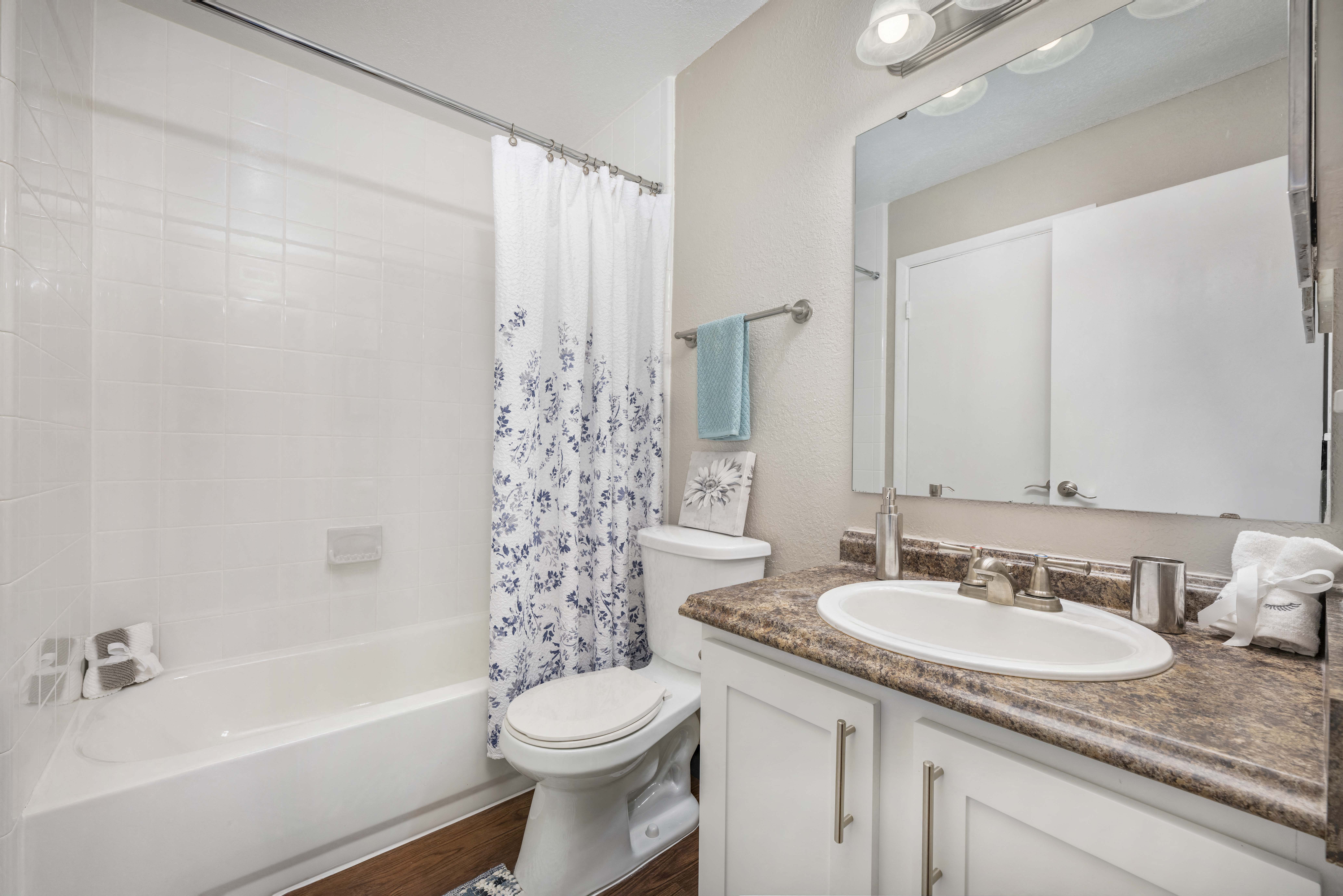 a bathroom with a shower toilet and sink and a mirror
