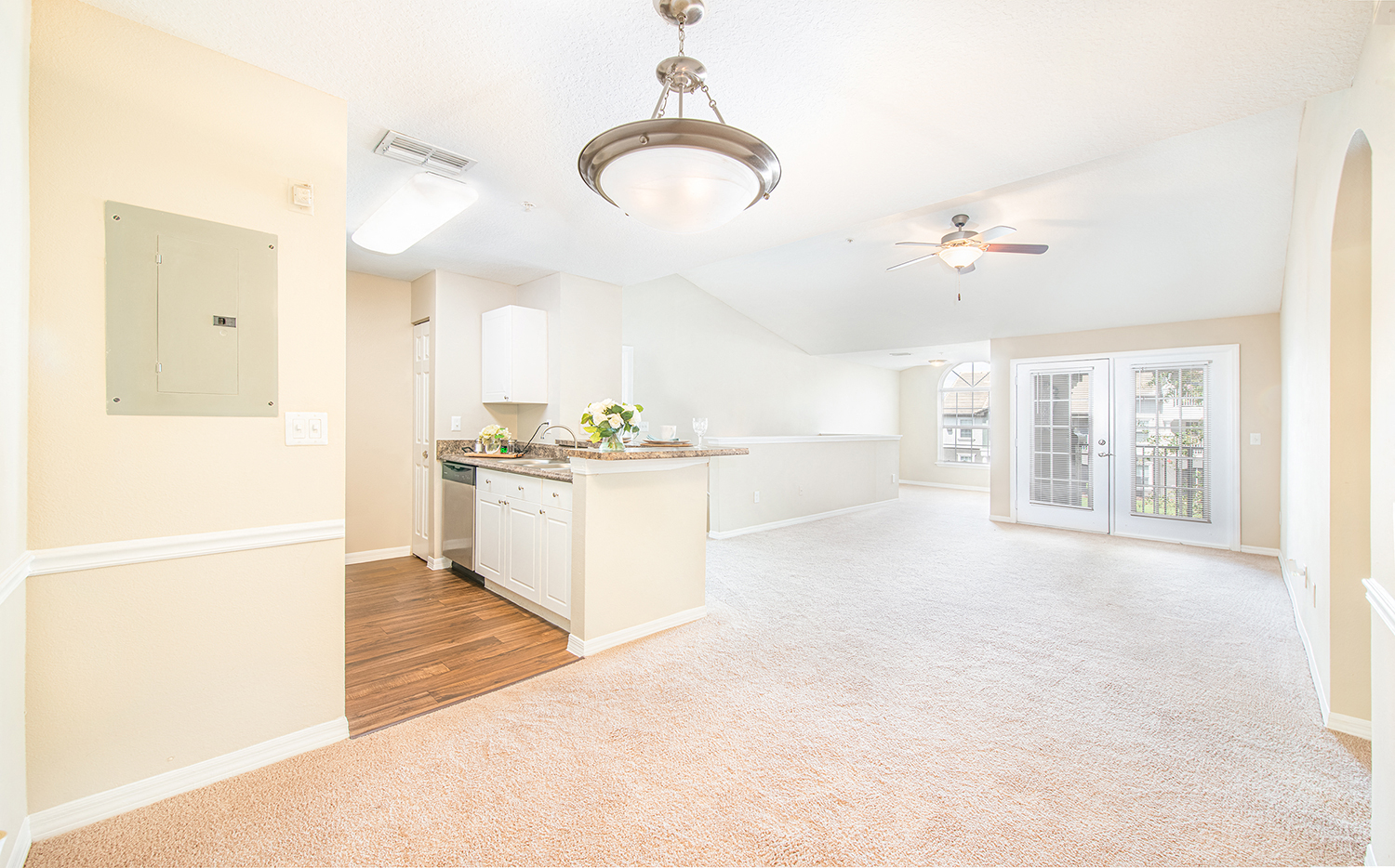 an empty kitchen and living room with a ceiling fan